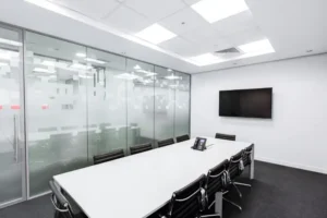 Glass conference room partition wall with a horizontal frosted confidentiality band at eye level